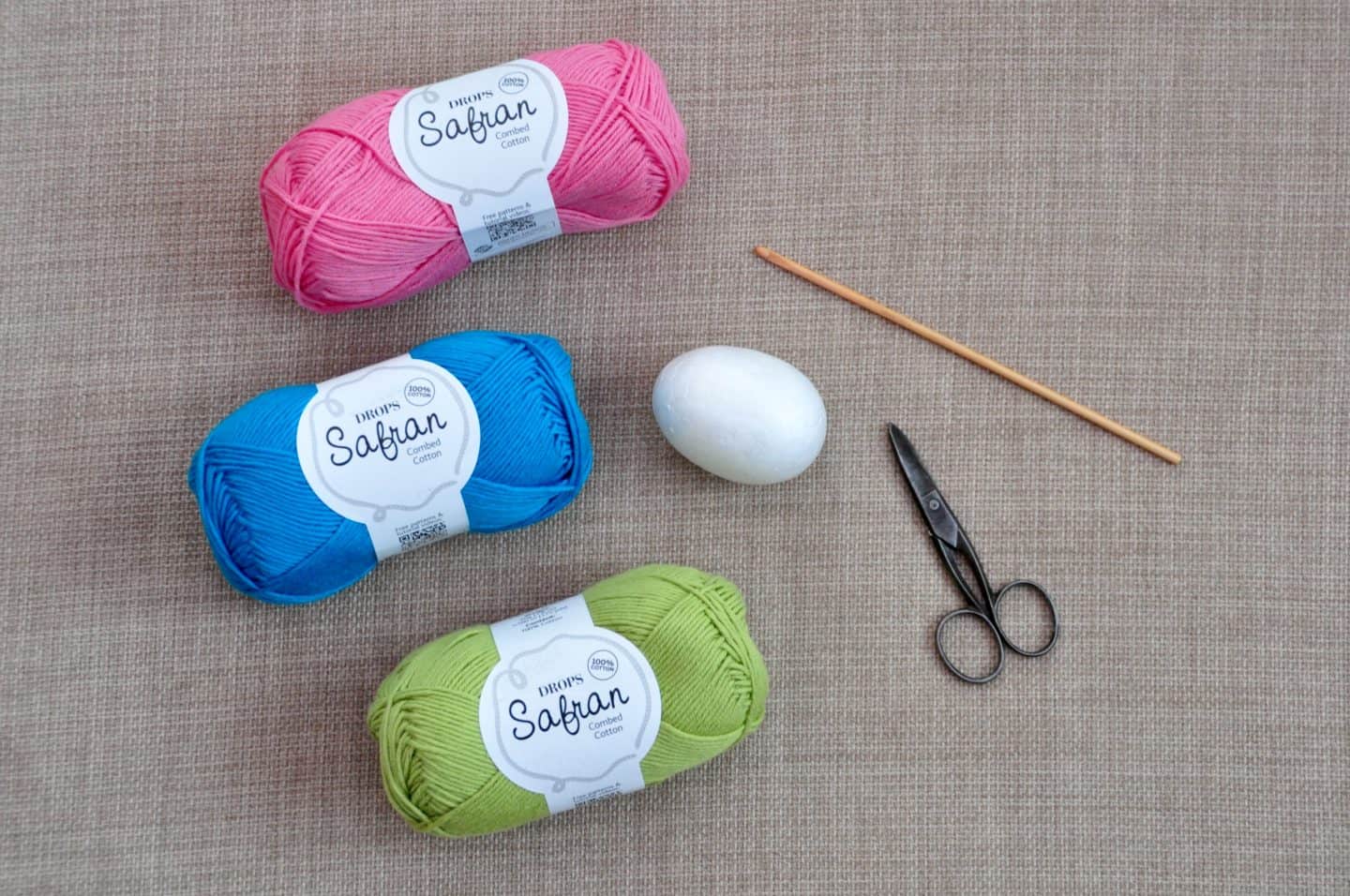yarn, crochet hook, scissors and polystyrene egg showing how to make crochet Easter egg