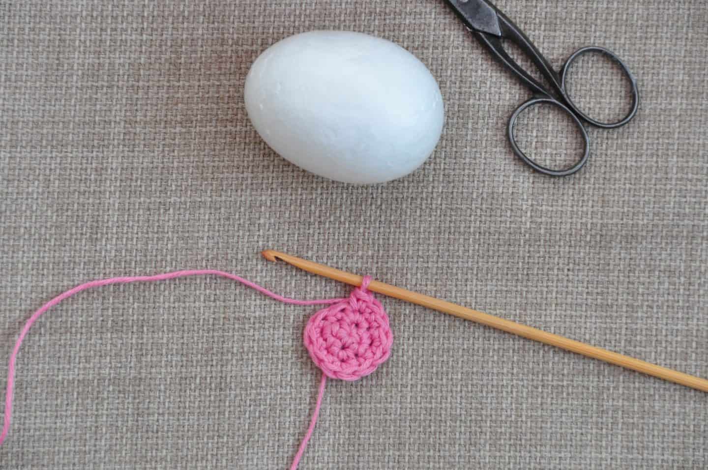small crochet circle with crochet hook showing start of amigurumi crochet Easter egg 