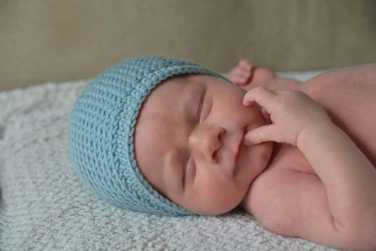 baby asleep wearing crochet beanie hat in blue