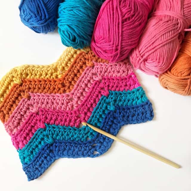 Learn to crochet the ripple stitch with this free crochet tutorial and crochet blanket pattern in both UK and US terms. Feel the retro decor vibe with bright colours or choose classic tones to make your crochet blanket perfect for you. Great for beginner crocheters. 