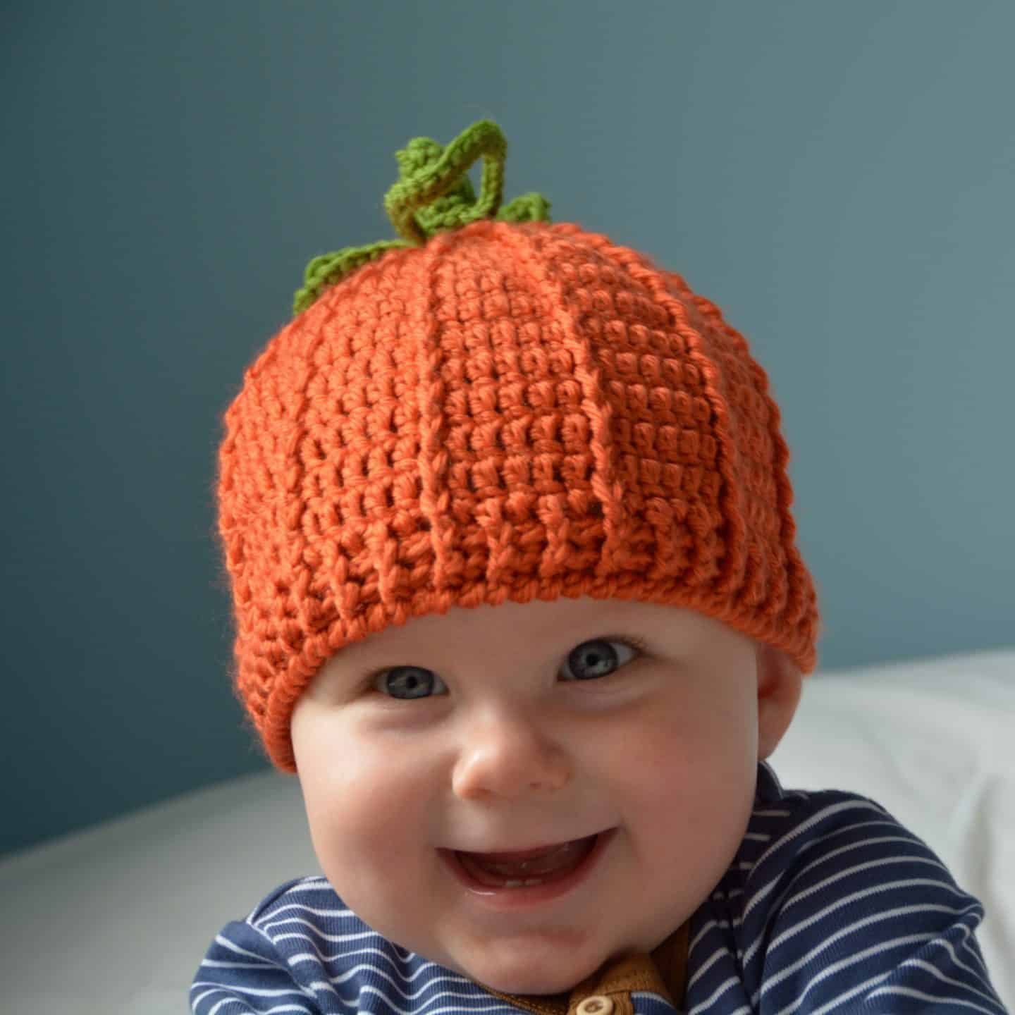 Smiling baby wearing a pumpkin crochet hat free pattern.