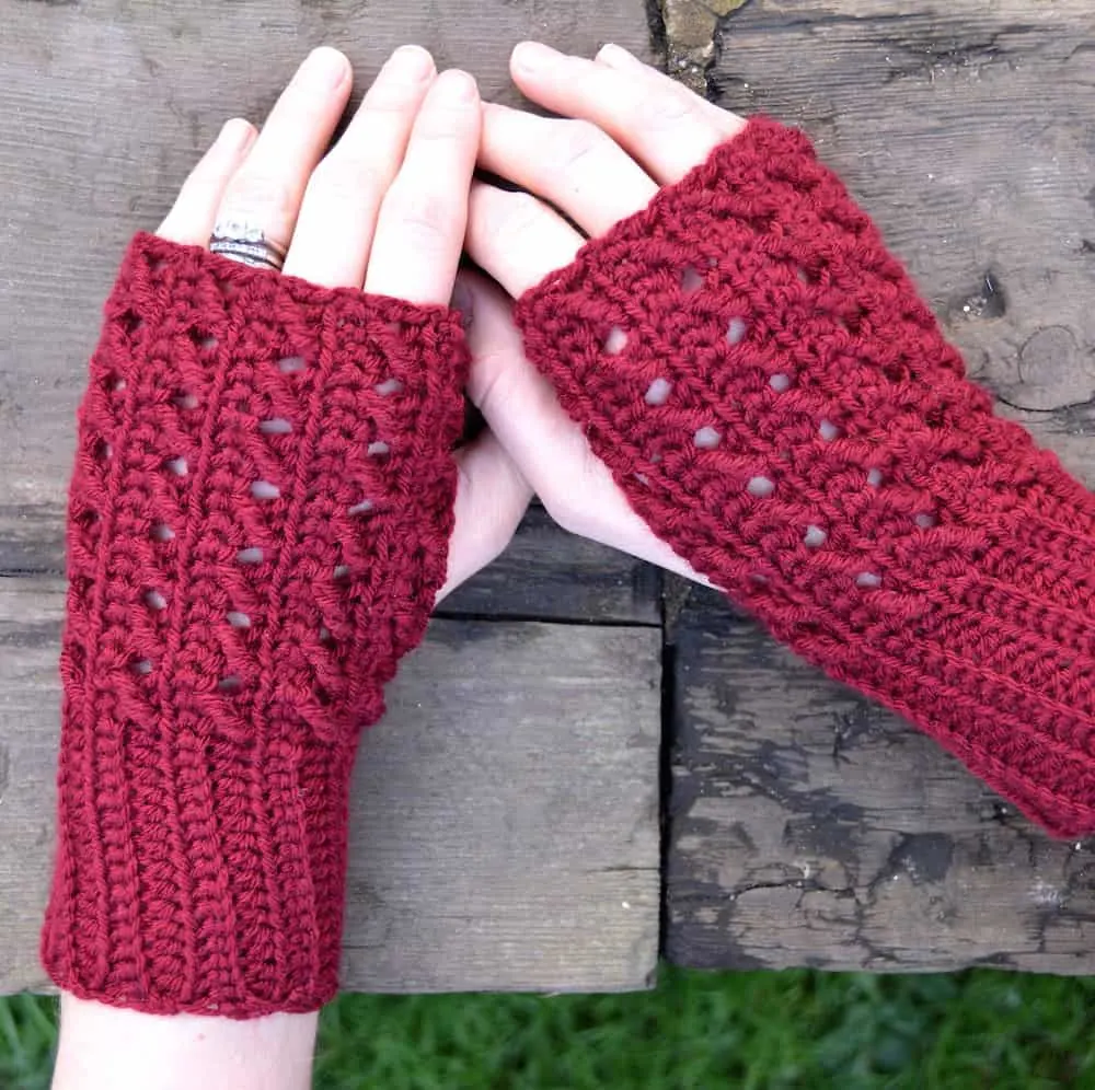close up of female hadst wearing fingerless easy crochet mittens in red