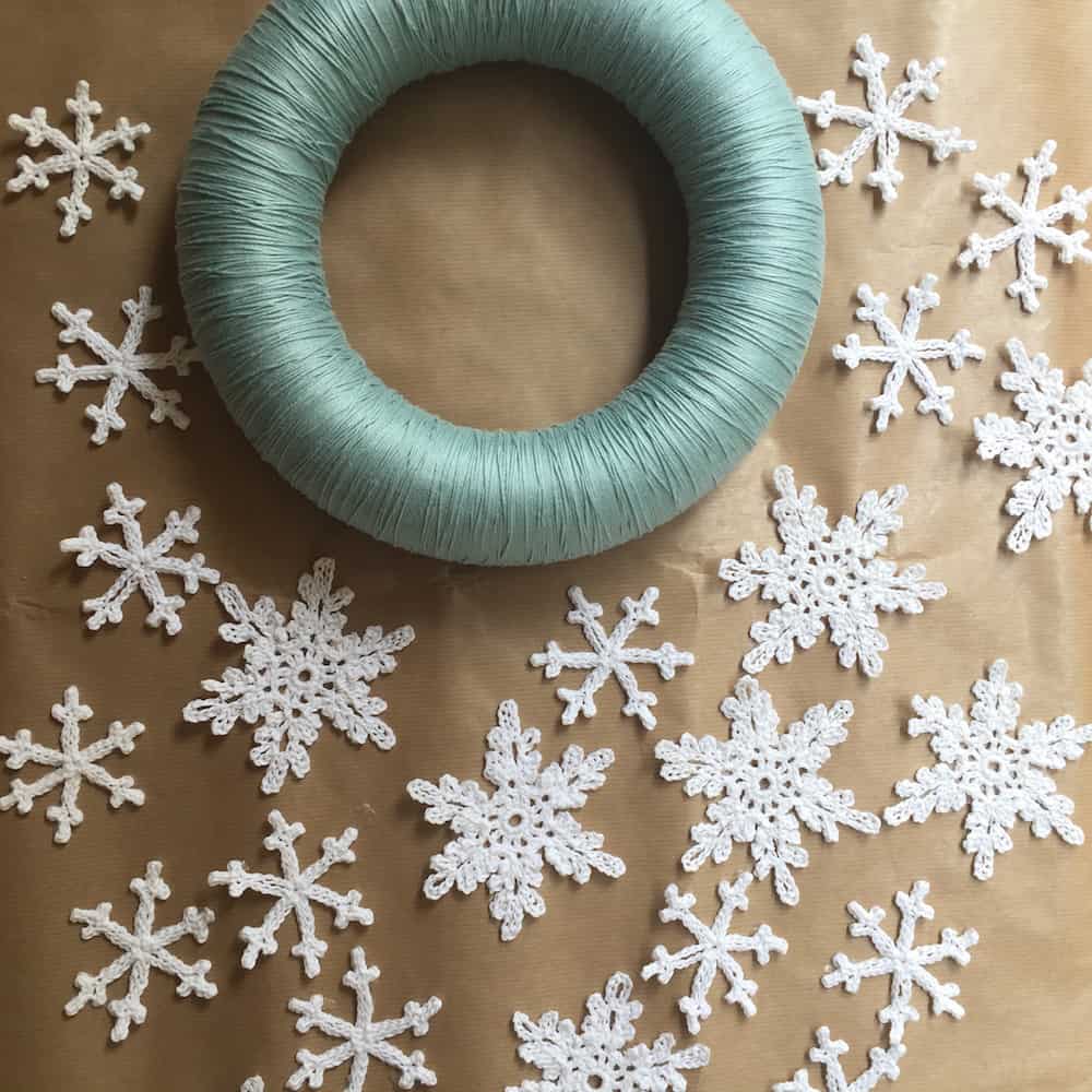 Foam ring with light blue yarn wound around it.