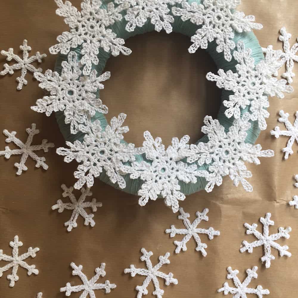 Crocheted snowflakes being glued onto a wreath.