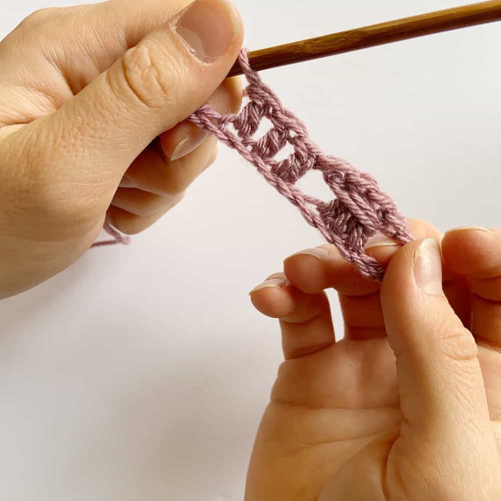 Learn the simple crochet cable stitch with this step by step tutorial and free crochet blanket pattern by HanJan Crochet. A beautifully delicate stitch for beginners learning to crochet that is perfect for baby blankets, cushions, scarves and much more. The pattern and tutorial is in both UK and US terms.