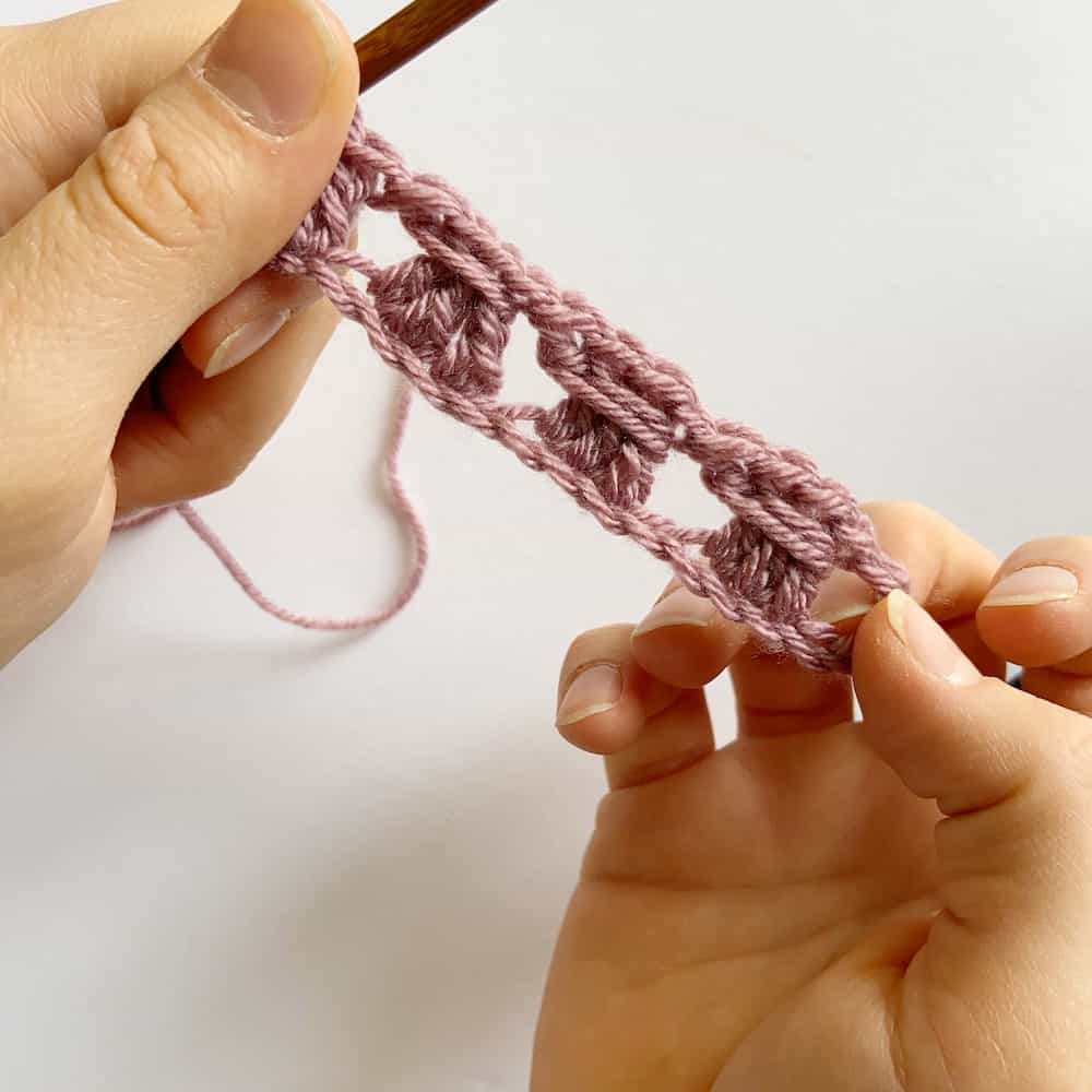 Learn the simple crochet cable stitch with this step by step tutorial and free crochet blanket pattern by HanJan Crochet. A beautifully delicate stitch for beginners learning to crochet that is perfect for baby blankets, cushions, scarves and much more. The pattern and tutorial is in both UK and US terms.