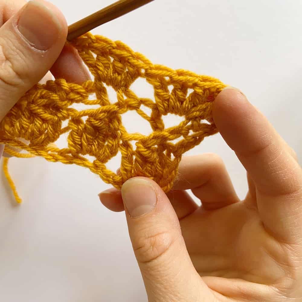 Learn to crochet the Cabbage Stitch with HanJan Crochet. A free step by step photograph tutorial to learn to crochet for beginners. The post also includes information about the free Oolong Blanket free crochet pattern by Hannah Cross.