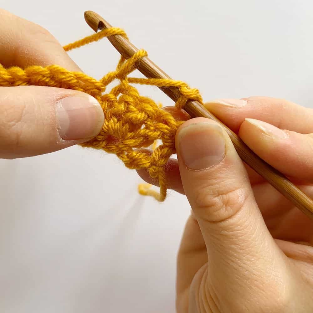 Learn to crochet the Cabbage Stitch with HanJan Crochet. A free step by step photograph tutorial to learn to crochet for beginners. The post also includes information about the free Oolong Blanket free crochet pattern by Hannah Cross.