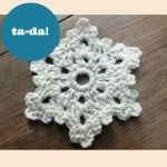 A beginner's crocheted snowflake on a wooden table.