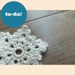 A crocheted snowflake with an easy pattern on a wooden table.