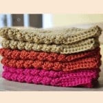 Four crocheted dishcloths stacked on top of each other in a pattern.
