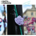 A crocheted flower pattern on a pole in the city of Bath.