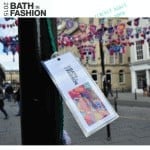 A crochet tag with the words bath in fashion attached to a pole.