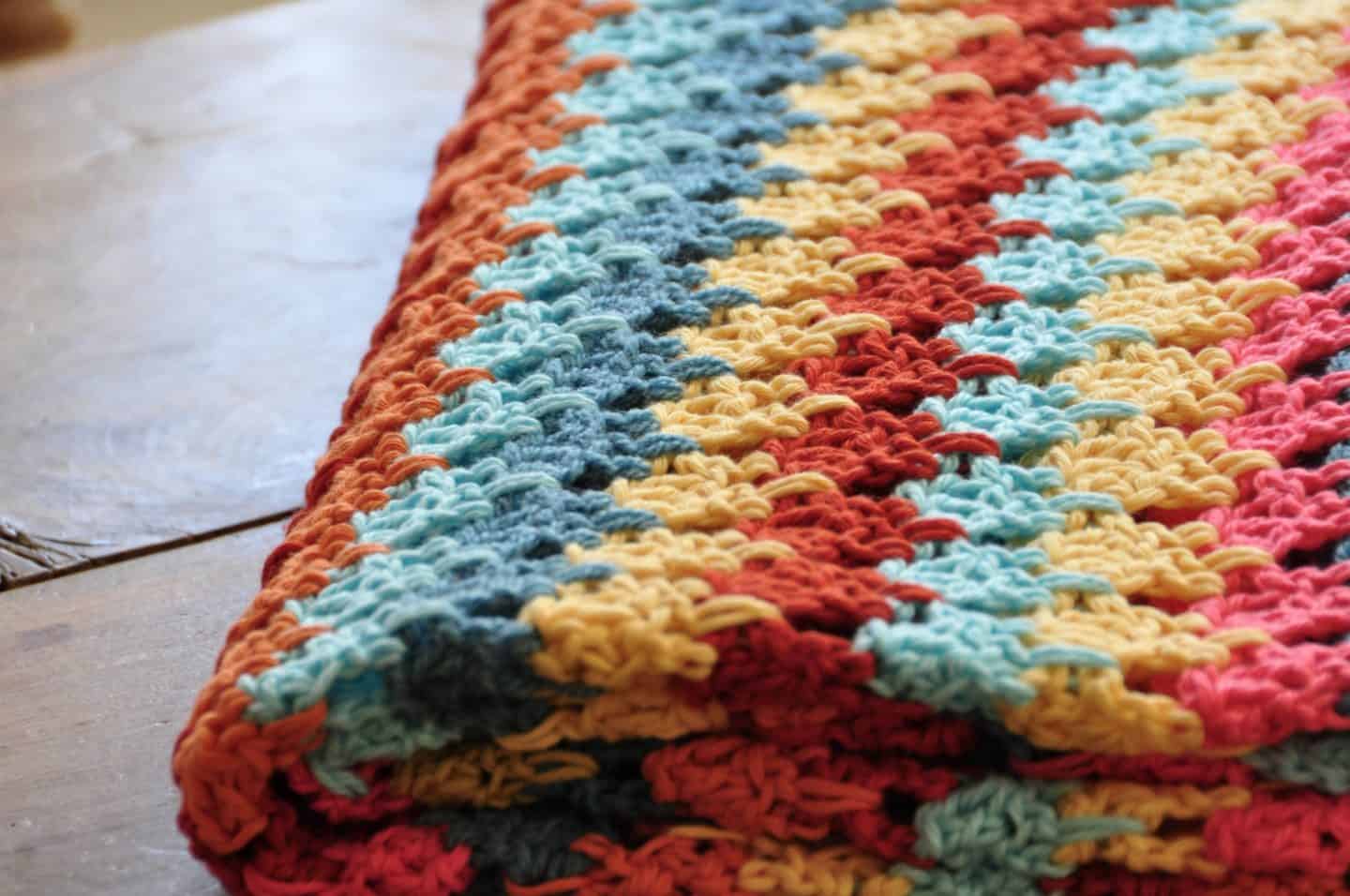 Tackle your yarn stash and learn how to crochet the larksfoot stitch with this beautiful and easy free crochet blanket pattern. With step by step photos and entire crochet pattern, the larksfoot makes the perfect baby blanket, home throw, scarf or garment that is great for a beginner.