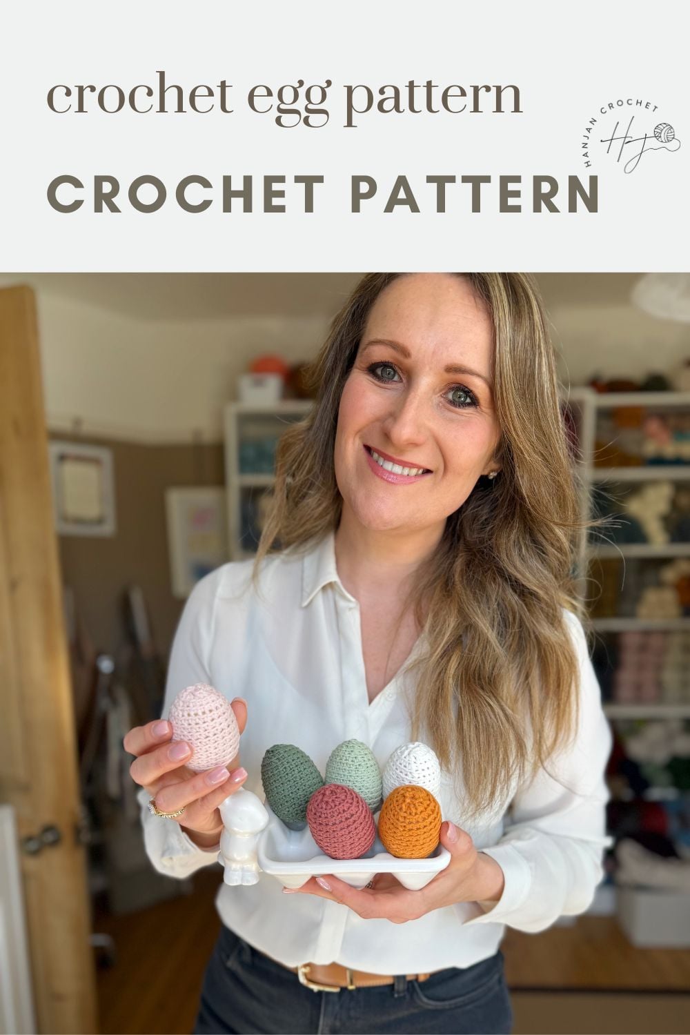 A woman stands indoors holding a tray with five colorful crochet Easter eggs, smiling at the camera. Text above reads "crochet egg pattern CROCHET PATTERN.