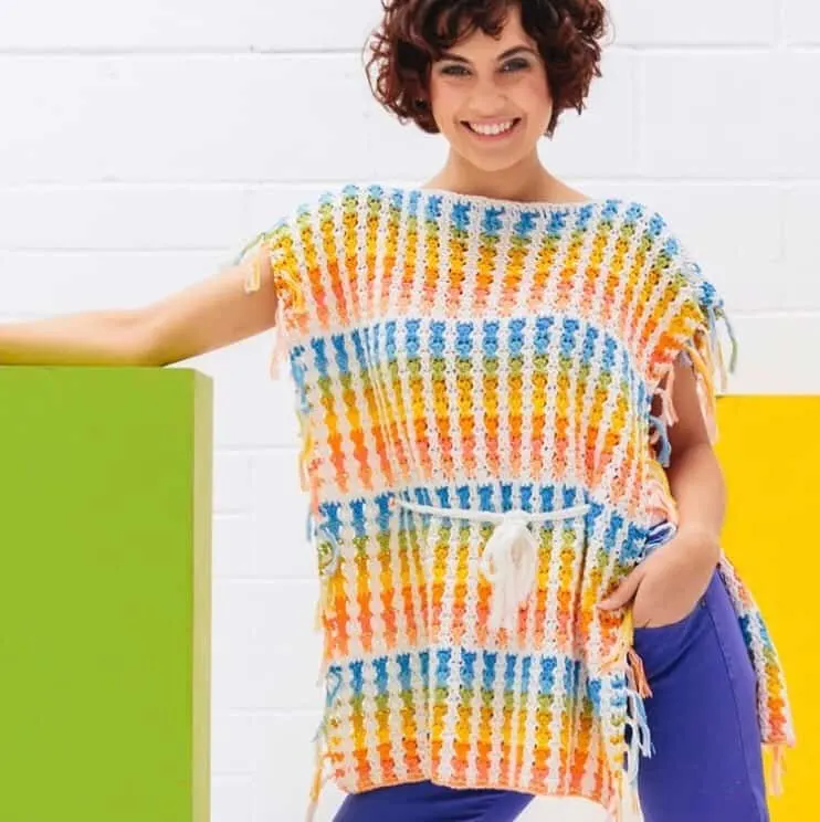 The Skittles Poncho, a bright and fun beginners crochet pattern by Hannah Cross of HanJan Crochet. A free crochet pattern to learn how to crochet in rainbow colours, a fun and easy summer make for you handmade wardrobe.