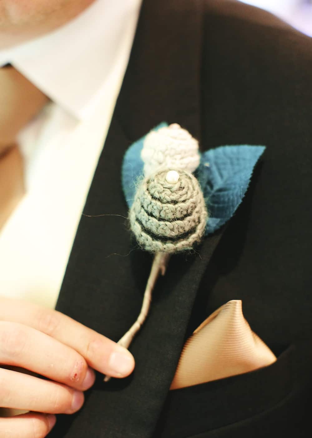 Close up of crochet wedding buttonhole flowers. 