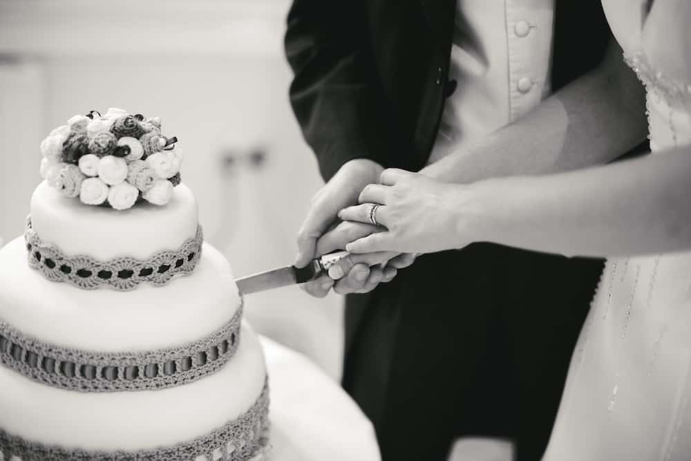 Sophisticated wedding cake with crochet flower topper and crochet cake collar.