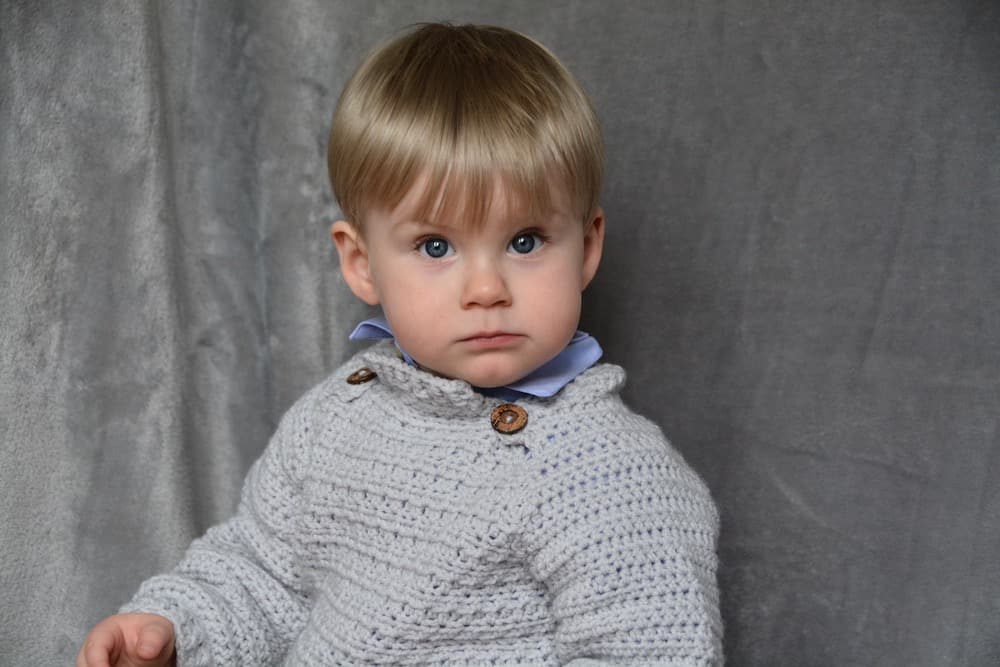 little boy in grey crochet baby jumper