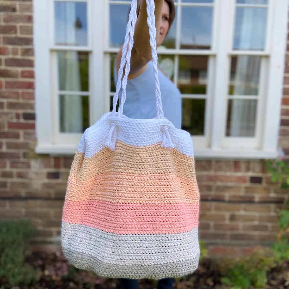 Free crochet pattern for the summer stripe beach bag. Pink, peach, grey and white bold stripe beach bag.