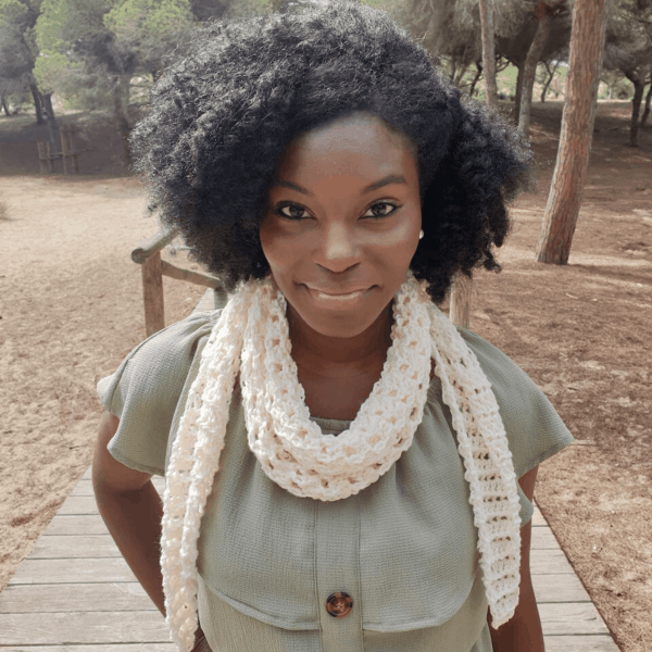 woman with afro smiling wearing cream crochet scarf