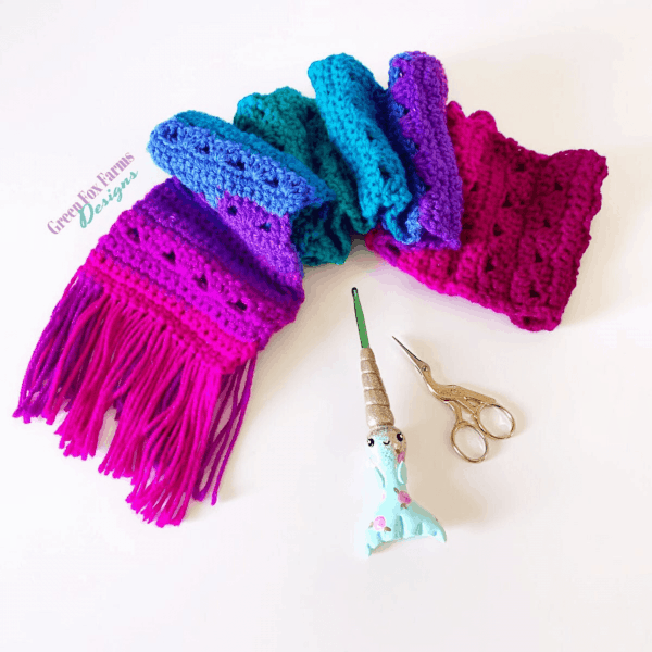 bright pink and purple scarf with crochet hook and scissors