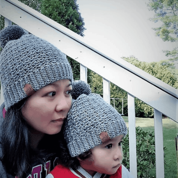 woman and child wearing matching grey crochet bobble hats