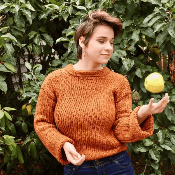 woman throwing an apple in organ crochet sweater