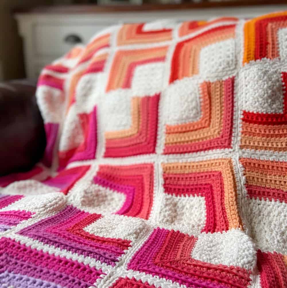 pink, purple, red, peach and white sqaure crochet blanket close up 