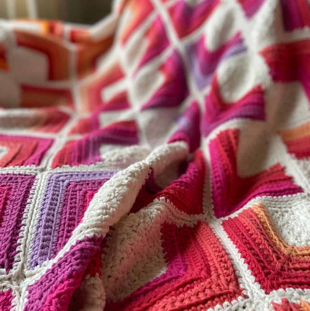 close up of square motif crochet blanket in bright and hot colours