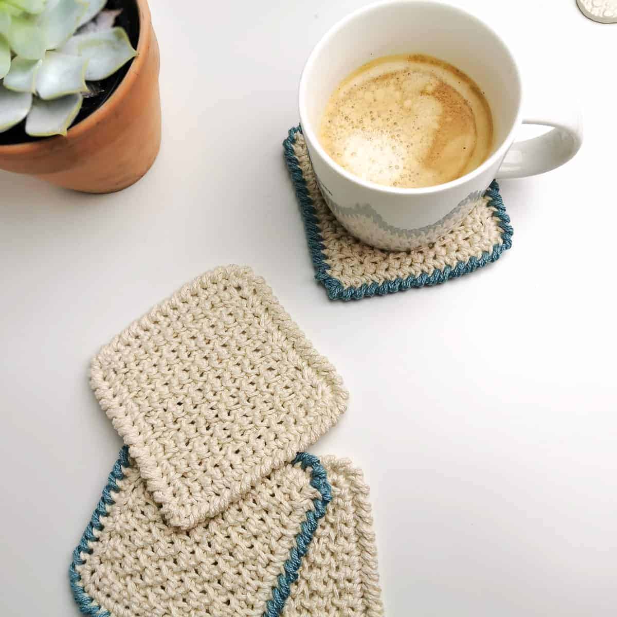 easy crochet coaster in cream and blue with a milky cup of coffee and house plant