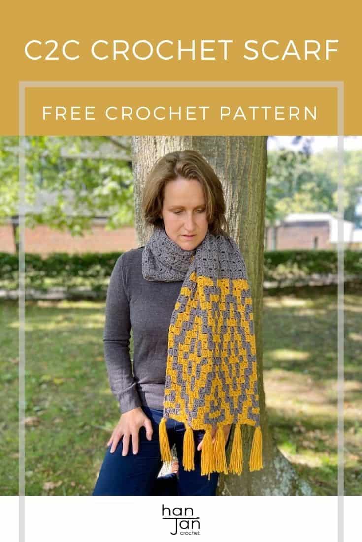 woman leaning against a tree wearing geometric design crochet scarf wrapped around her neck