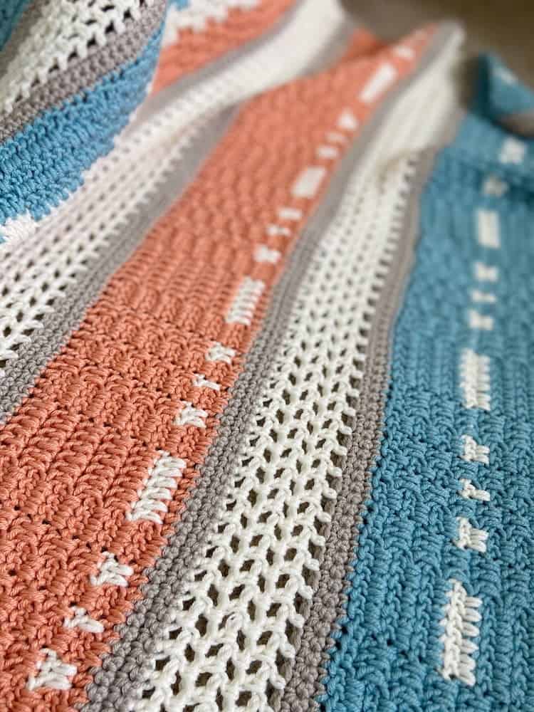 Close-up of filet and moss stitch in modern crochet blanket for babies.