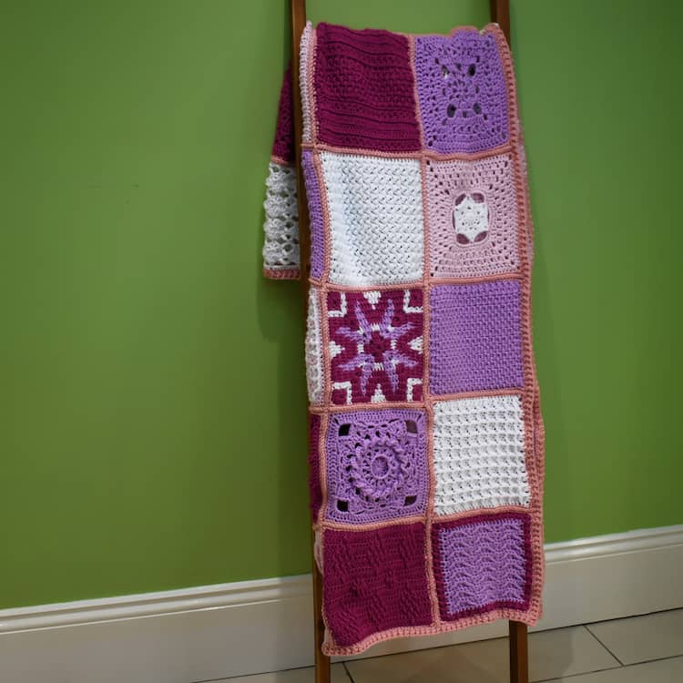 friendship CAL crochet blanket displayed on ladder leaning against a wall