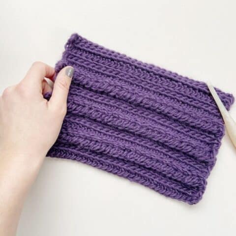 crochet braid stitch swatch with crochet hook and hand