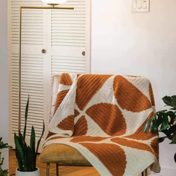 Crochet throw on chair with semi circle pattern.