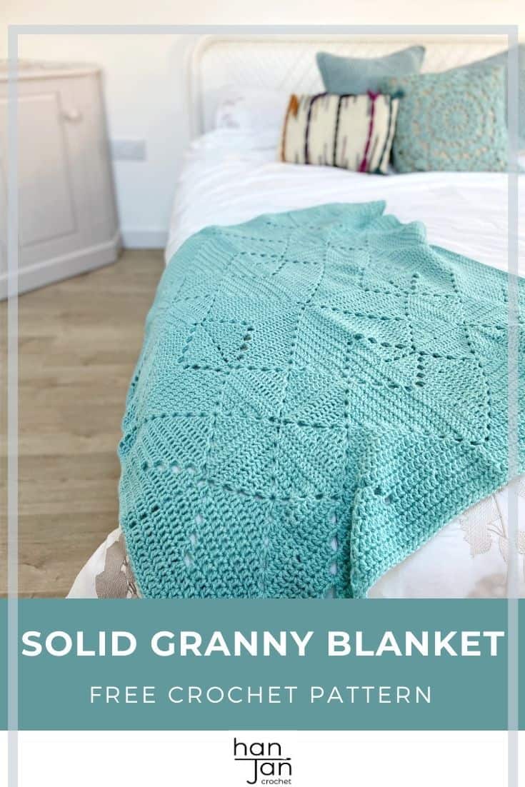 Teal crochet solid granny square blanket laid one end of bed.