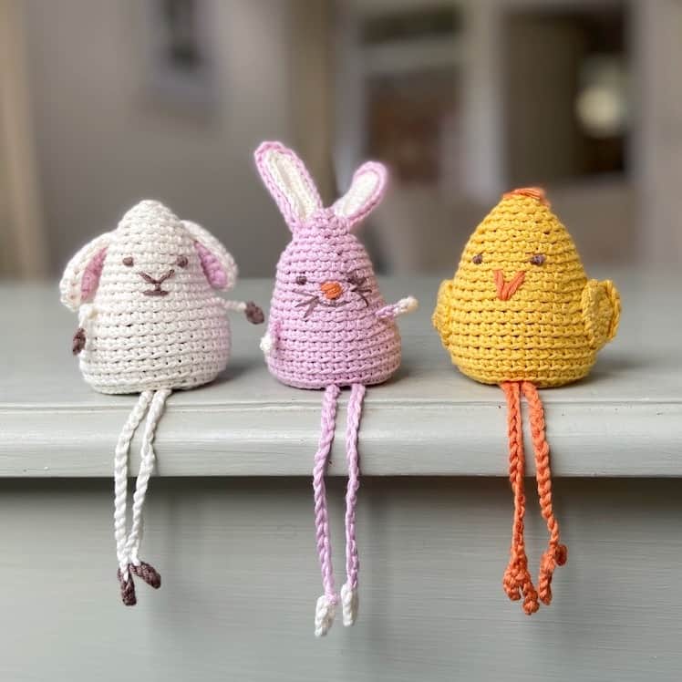 amigurumi crochet bunny, chick and lamb with dangly legs sitting on shelf