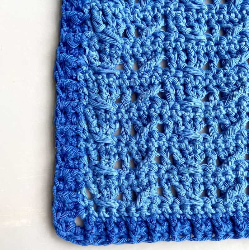 close up of crochet cable stitch pattern in blue cotton yarn