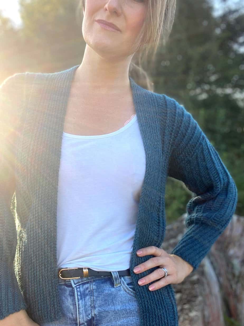 Woman with hands on hip wearing ribbed crochet cardigan pattern.