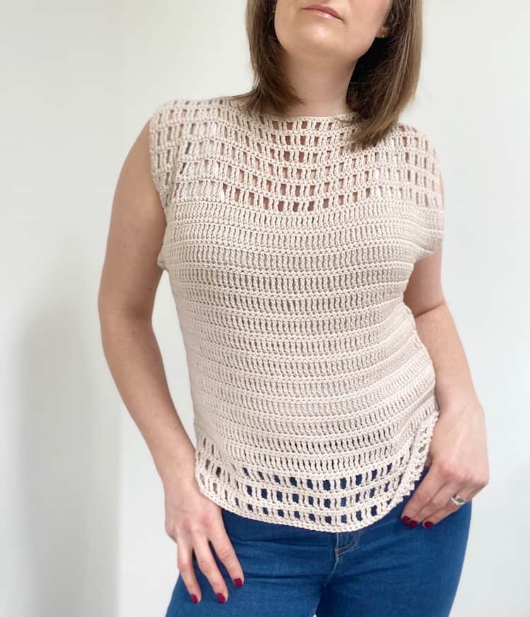 woman looking down wearing cream lace crochet summer top