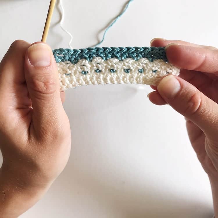 Hands holding white and blue crochet.