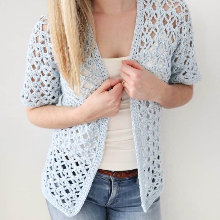 woman wearing light blue short sleeved crochet cardigan