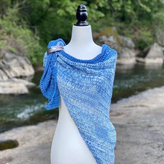 riverside blue crochet shawl on mannequin with buckle at shoulder