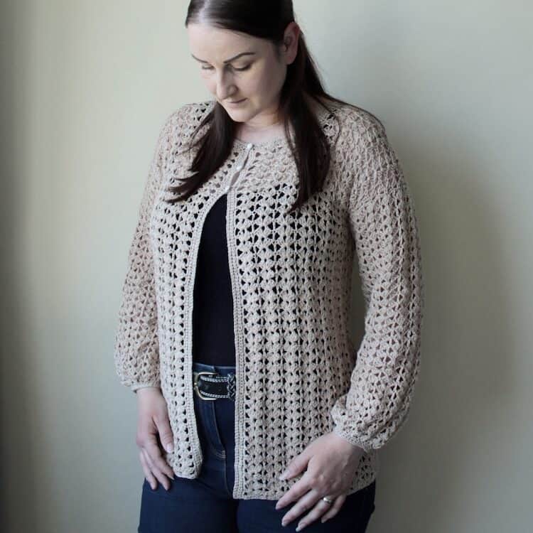 woman wearing long sleeved lace crochet cardigan in cream 