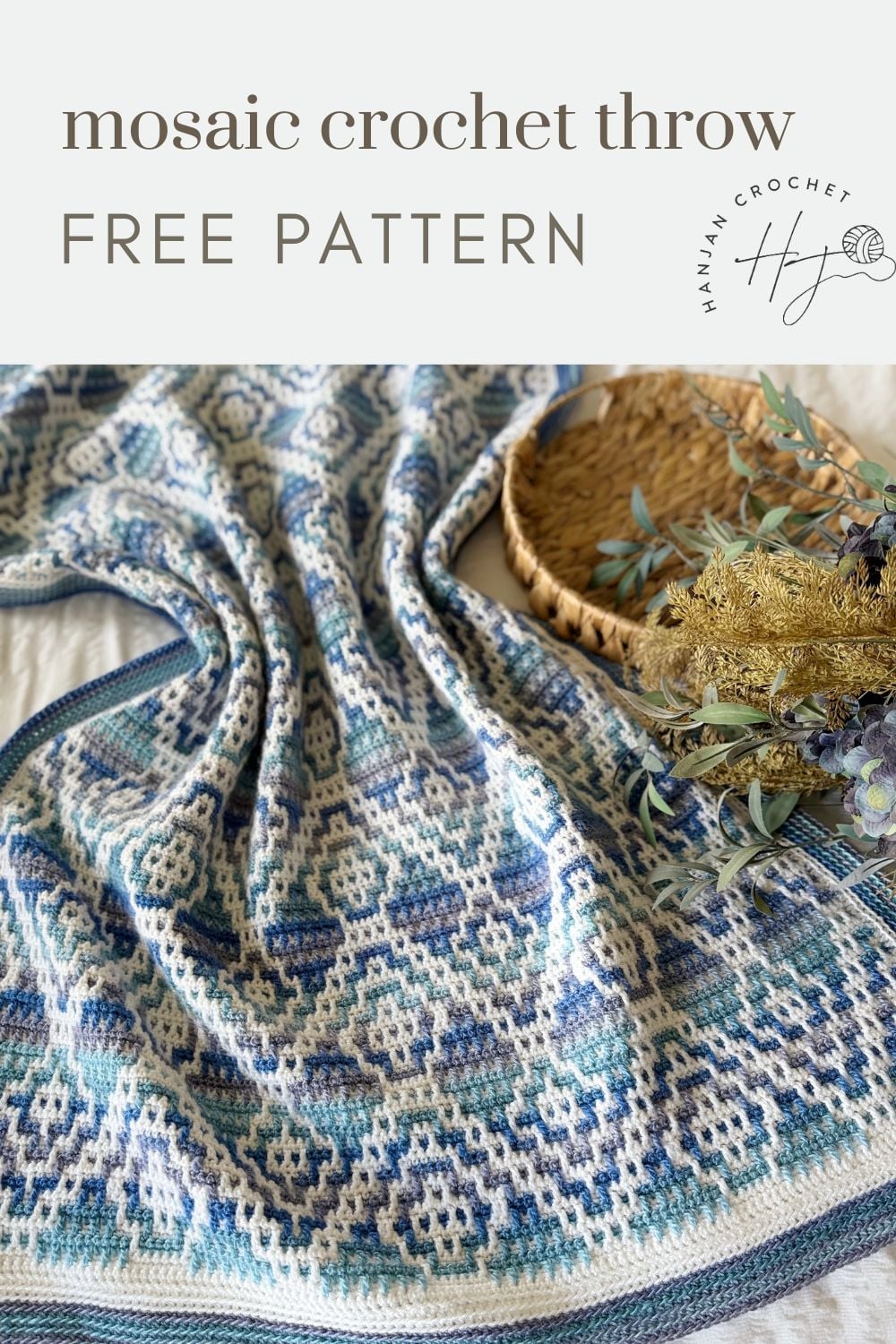 Blue and white mosaic crochet blanket displayed on a surface next to a woven basket with dried flowers; text reads "mosaic crochet throw free pattern.
