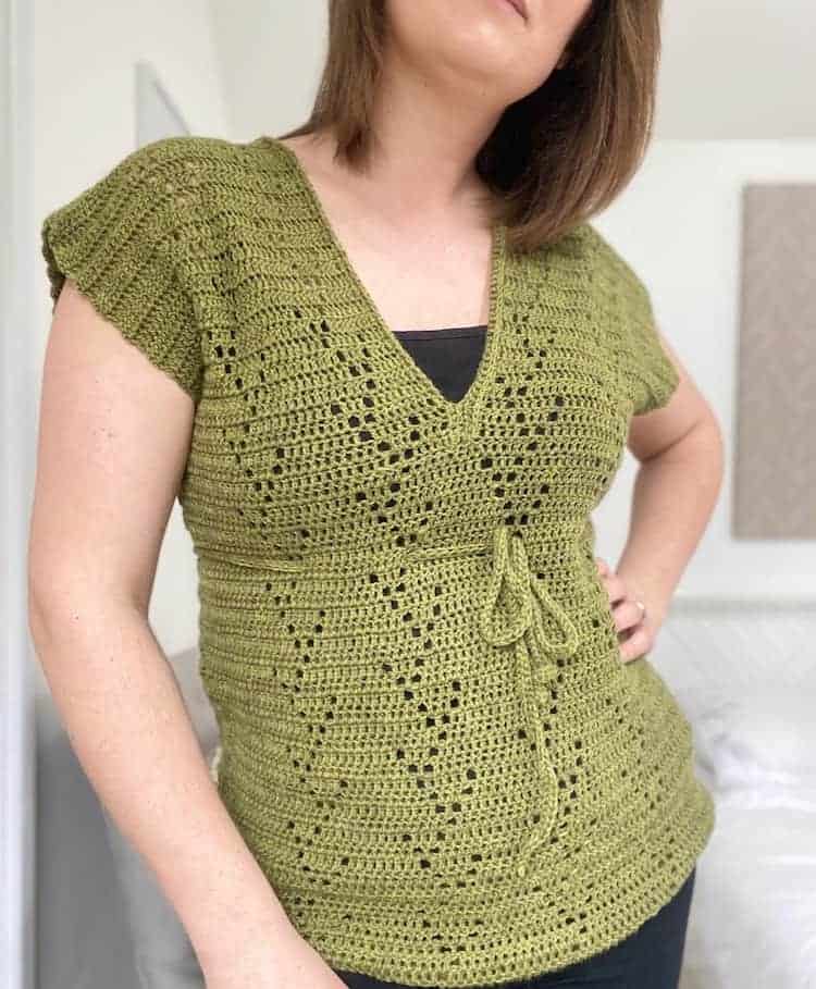 woman wearing green filet crochet t-shirt with hand on hip