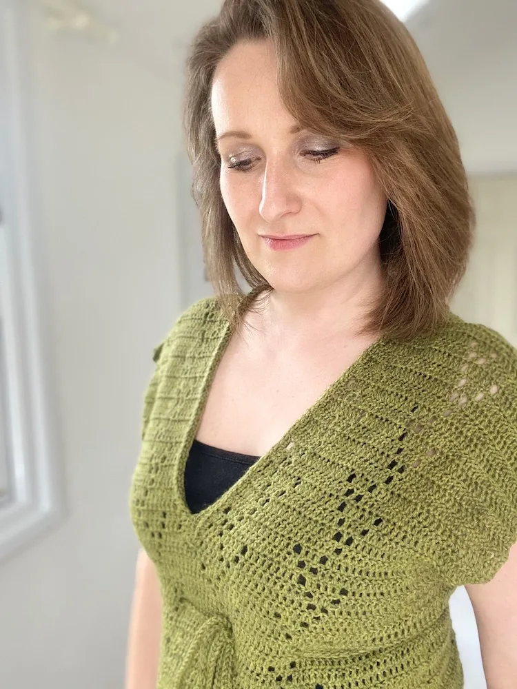 woman looking down wearing V neck crochet t-shirt with filet crochet detail 