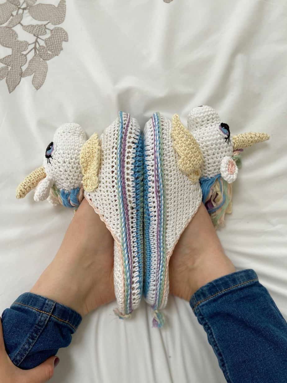 overhead image of person wearing unicorn crochet slippers pattern with soles together in lotus position