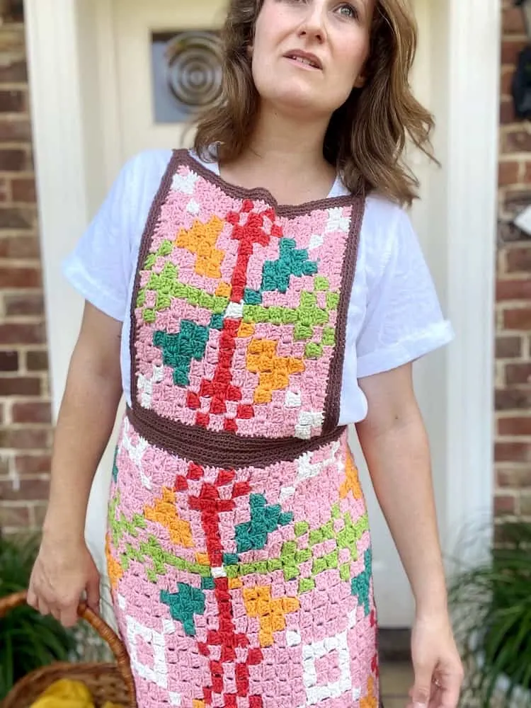 woman moving forwards wearing retro crochet apron with bright pattern